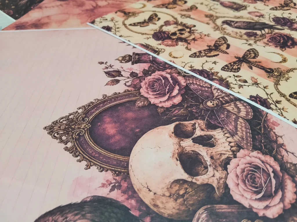 Layered printed papers with moths, skulls, roses, ravens and pale journaling lines